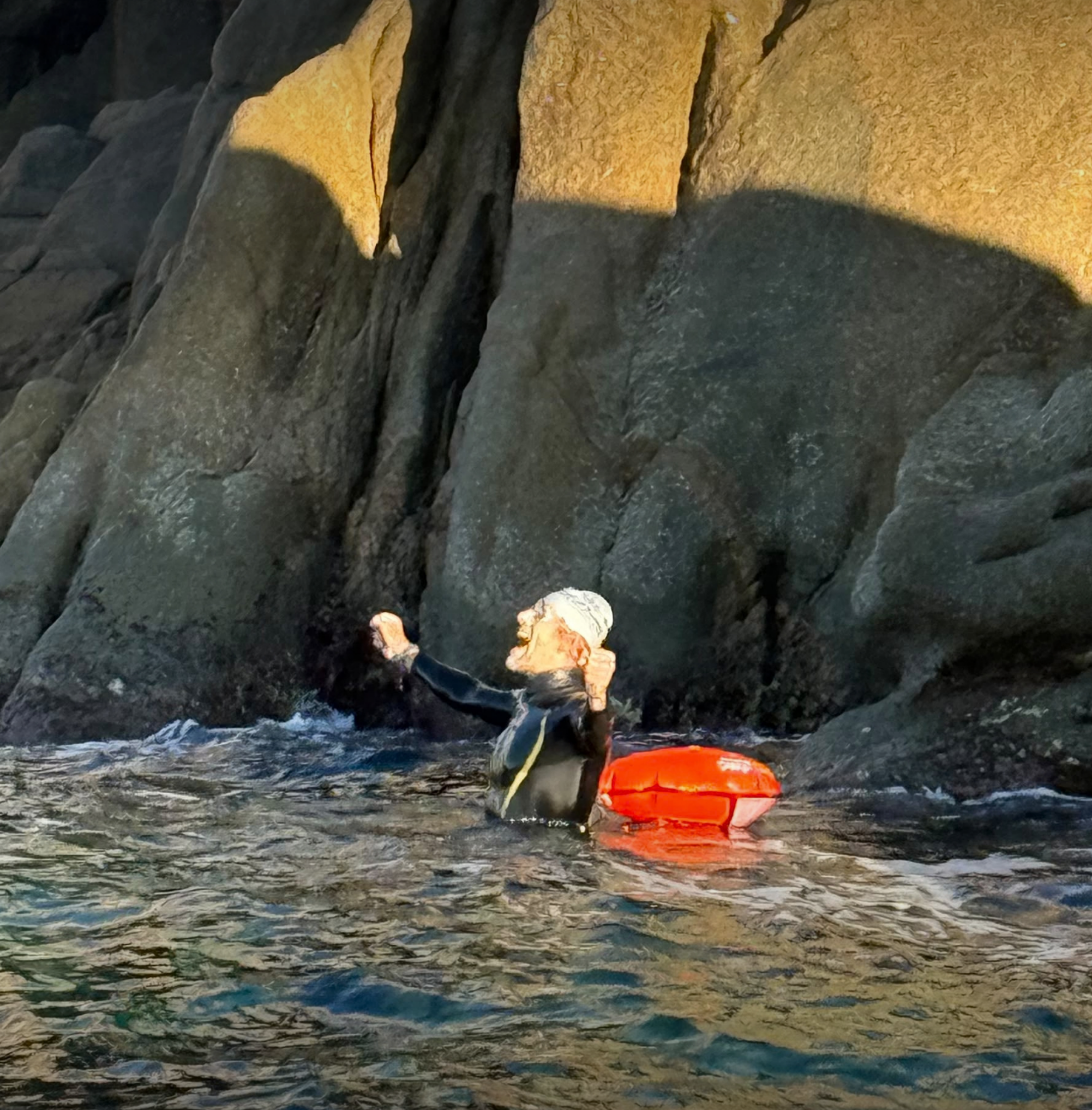 Nicolas Felger dans l’eau près des rochers, sur le visuel de sa traversée Sardaigne–Corse aller-retour