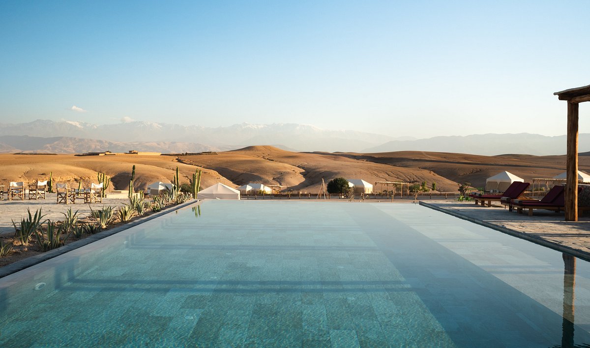 Vue sur la piscine du camp, les collines du désert d’Agafay et les montagnes de l’Atlas