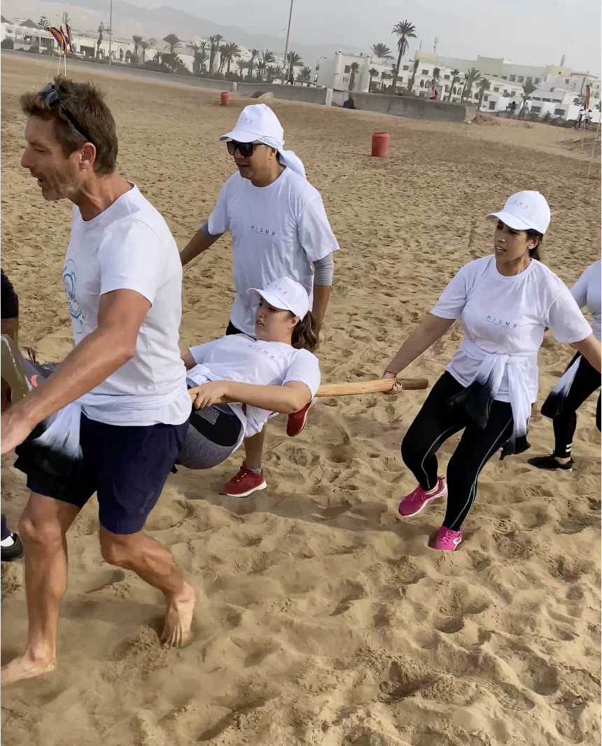 Équipe transportant une coéquipière sur un brancard lors du team building Koh-Lanta
