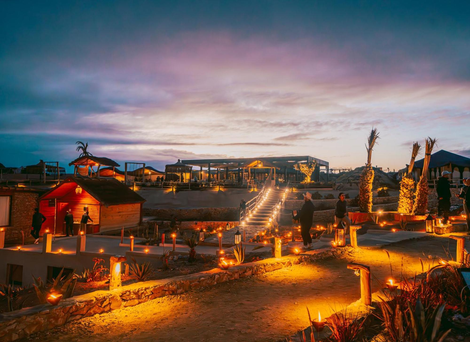 Le camp du désert d’Agafay illuminé de lanternes au coucher du soleil