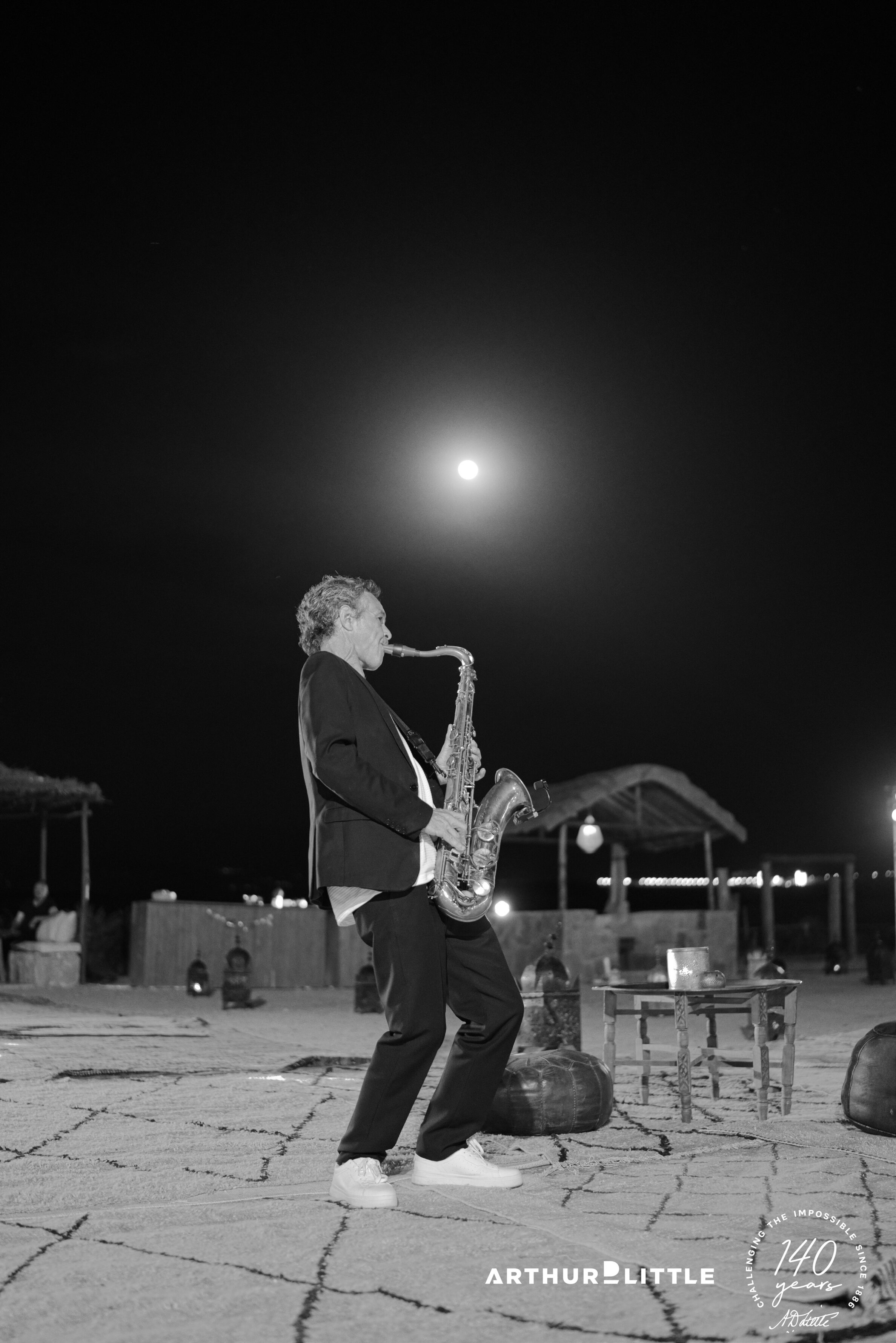 Un saxophoniste joue en plein air sous la lune pendant la soirée de gala dans le désert d’Agafay